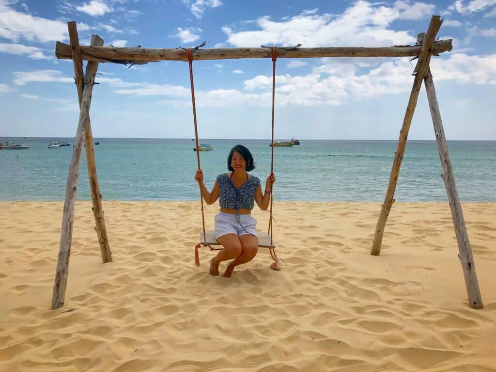 Fabienne assise sur une balançoire sur la plage de Ky Co 