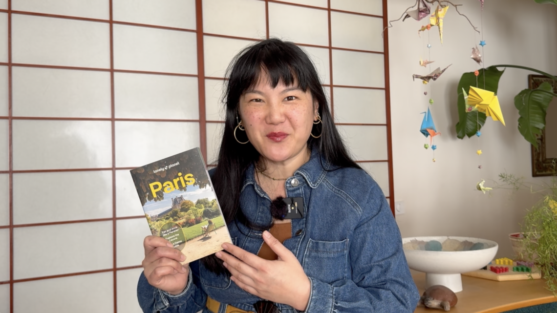 Fabienne holding the 2026 Lonely Planet Paris Guidebook