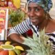 Esperanza Aguilar, souriante, pose à côté d'une assiette d'empanadas colorés.