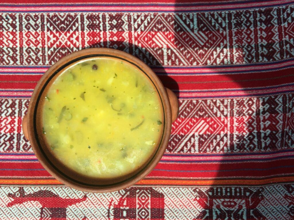 Soupe de Quinoa prise d'en haut, sur une nappe aux motifs typiques des Andes.