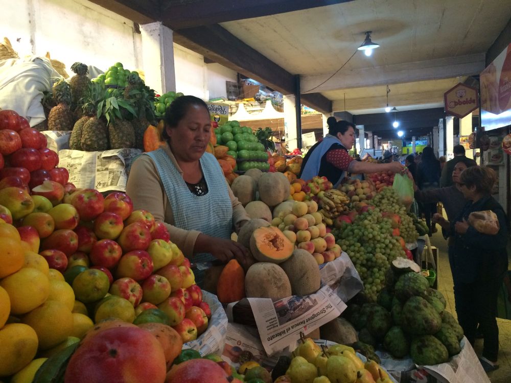 un étal de fruit et une vendeuse en Bolivie