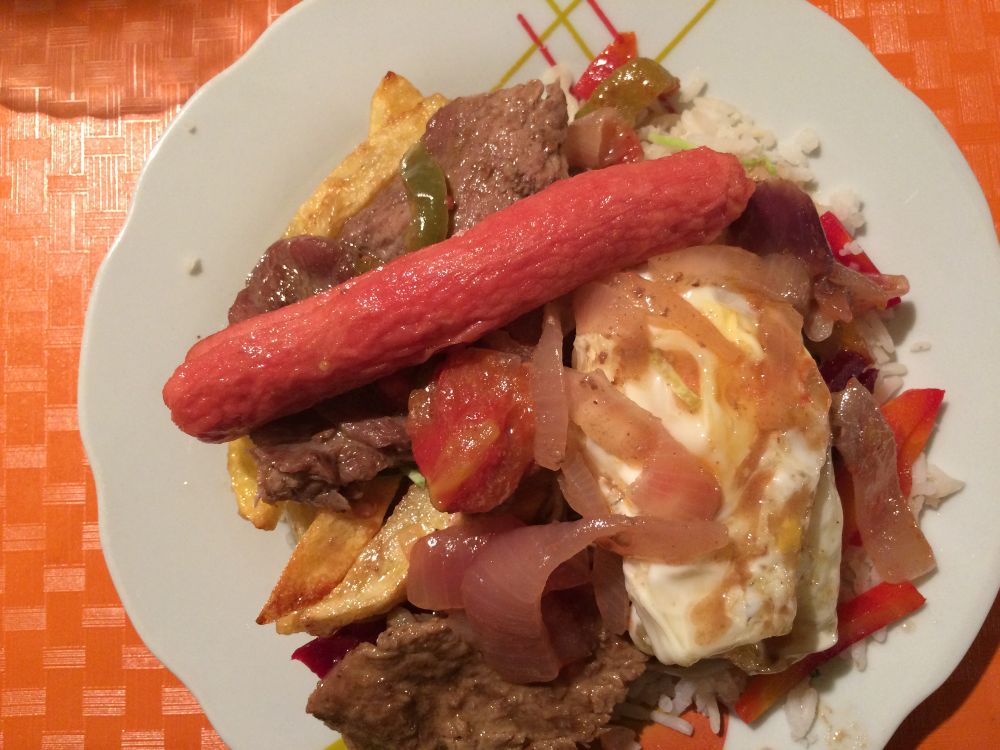 assiette très garnie vue d'en haut : saucisse oeuf au plat riz et frites
