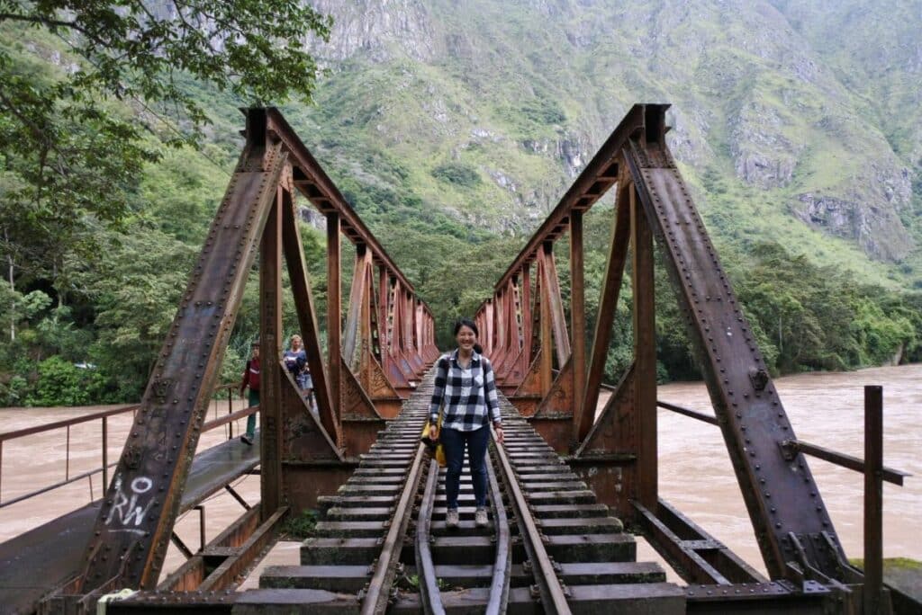 portrait de l'auteur devant les rails du pont qui passe au dessus de la riviere urubamba